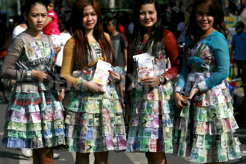 Promosikan money changer, gadis cantik ini pakai baju dari uang kertas